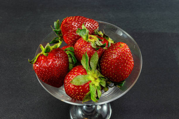 istock strawberries in a tall bowl on a black background 1404046348