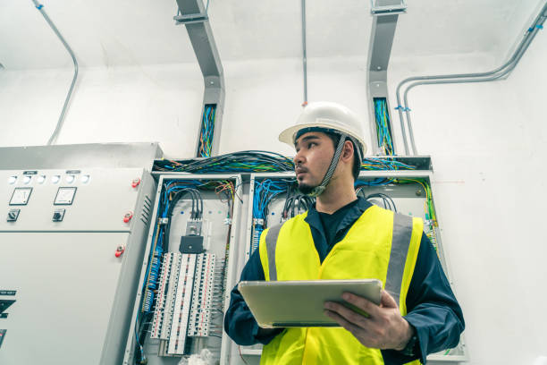 istock Professional Electrical Engineer or Electrician service working use tablet inspection electrical at control panel room. 1404047791