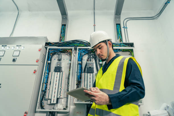 ingénieur électricien professionnel ou électricien travaillant utiliser l’inspection électrique de la tablette électrique dans la salle du panneau de commande. - electricity industry factory control panel photos et images de collection