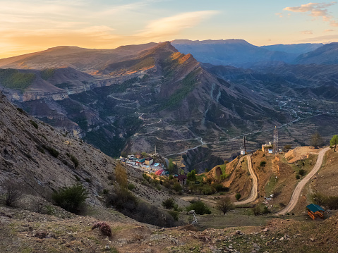 Authentic city with serpentine dirt road in the rock. Vintage Dagestani mountain village of Gunib in sunrise. Russia.