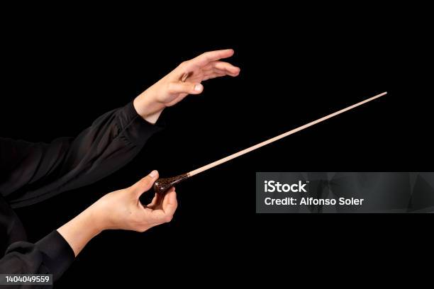Female Conductor Conducting A Symphony With Her Baton On A Black Background Stock Photo - Download Image Now