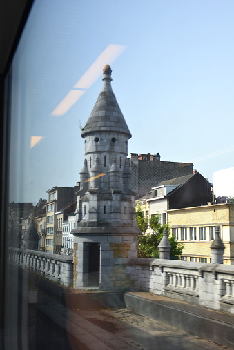 Antwerp, Belgium June 18, 2022:  motion blur photographing the outside railway from inside a passengers train. View on the sculpture fence railing piramide towers in limestone