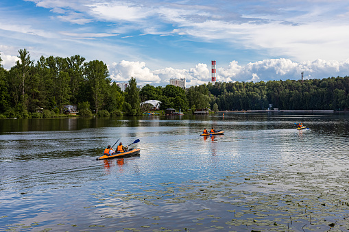Moscow, Russia - June 18, 2022: double canoe with people floats on the river in the park. High quality photo