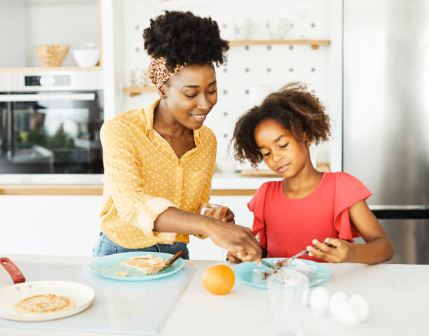 rodzina dziecko kuchnia jedzenie córka matka uwielbia jeść przygotowanie naleśnikowe śniadanie szczęśliwy razem czarny deser - whoopee pie zdjęcia i obrazy z banku zdjęć