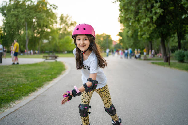 Cute little girl riding on roller skate in public park stock photo