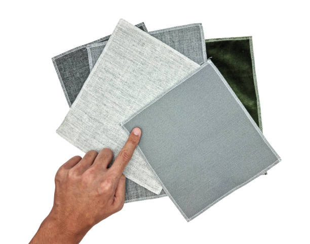 istock architect's hand choosing curtain fabric samples contains grey textile, grey sackcloth, green velvet textures isolated on background with clipping path. drapery or upholstery samples for selection. 1404051173