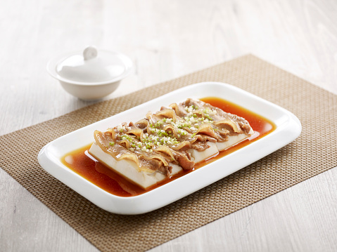 Steamed Spring Water Tofu with Shrimp Paste and Pork Belly with chopsticks served in a dish isolated on mat side view on grey background