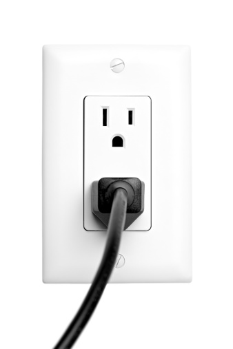 power outlet with plugged in cord, closeup isolated on white. limited dof, focus on outlet.