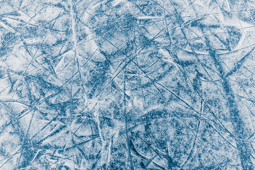 Winter background of frozen lake surface with a scratch from skates. Winter sports texture.