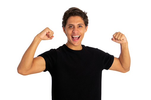 young man celebrating victory over white background.