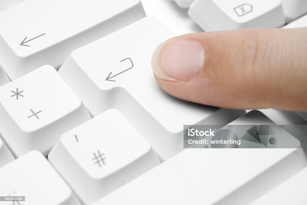 Pressing Enter Forefinger pressing the ""enter"" button on a white keyboard. Accessibility Stock Photo