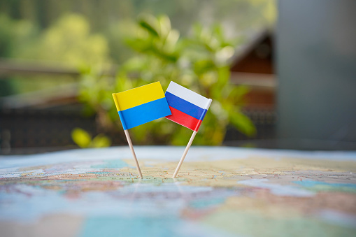 Small Ukrainian and Russian flag in the centre of a map surrounded by flags of ohter nations. Sony ALpha 7 III, 35mm.