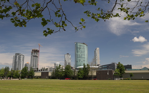 Surrey, Canada - June 17, 2022: View from Holland Park looking north of Old Yale Road in downtown Surrey. Upscale residential, office and hotel buildings line Surrey City Centre. Spring morning with light clouds over Metro Vancouver.