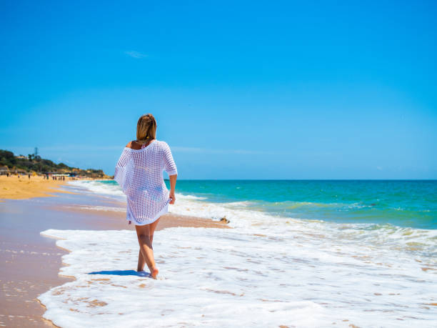 istock Beautiful woman walking on beach 1404053452