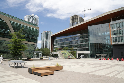 Surrey, Canada - June 17, 2022: Surrey Civic Plaza offers a popular venue for festivals and other gatherings outside Surrey Library and Surrey City Hall. Modern residential buildings are under construction the Whalley neighborhood in the background. Spring midday in Metro Vancouver.