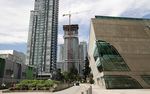 Surrey, Canada - June 17, 2022: Looking west along Central Avenue outside Surrey Library, City Centre Branch. Residential buildings are under construction in this neighborhood of Whalley in downtown. Spring midday in Metro Vancouver.