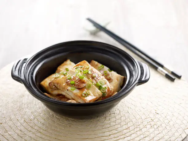 Pan-seared Hakka Stuffed Tofu with chopsticks served in a dish isolated on mat side view on grey background