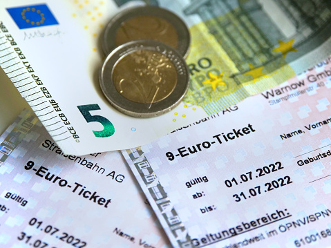 Rostock, Germany - Jun 20, 2022: 9 Euro Ticket with euro banknotes and euro coins. cheap travel nine euro ticket in germany for public transport. basic social security. Inflation and social crisis.