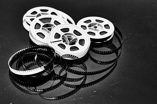 Still life of old movie film from the early 1960s, shot in grainy black-and-white.