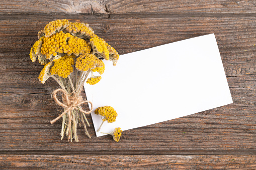 Yarrow Tea, and paper card on a Rustic Wooden Background