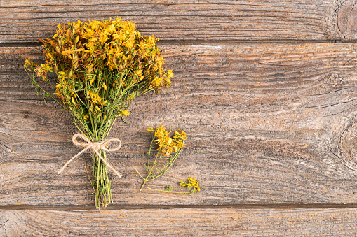 Dried St. John's wort plant on wooden background