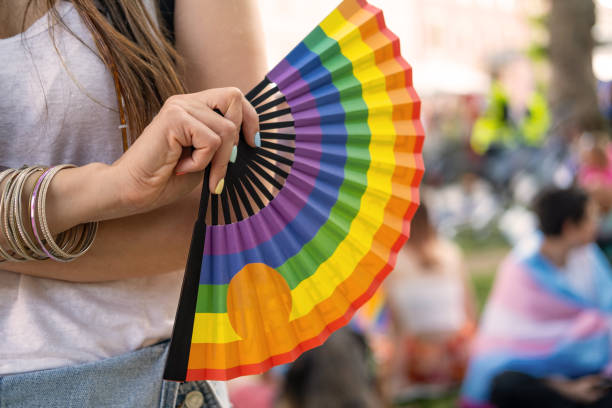 istock Woman holding rainbow hand fan. 1404064088