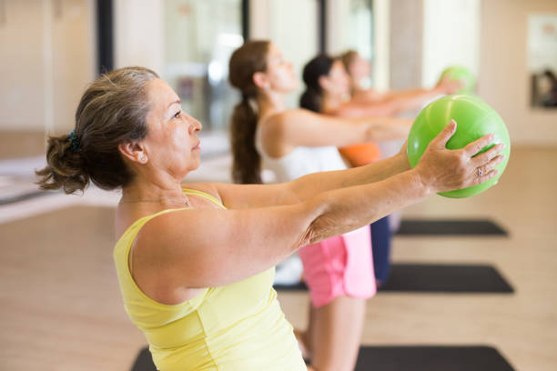 istock Sporty women doing exercises with pilates balls during group training 1404064252
