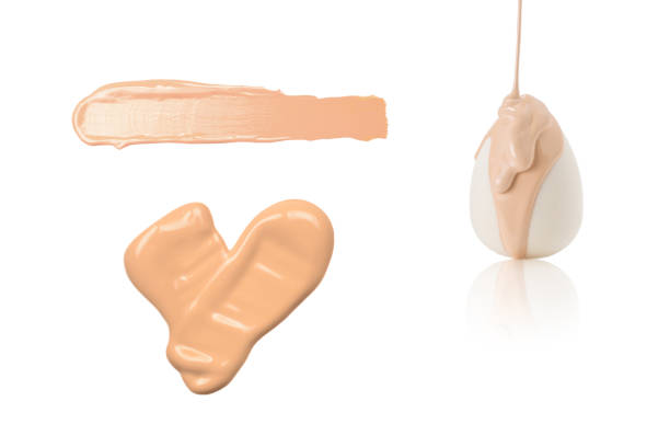 istock Liquid beige makeup foundation pouring on new white sponge isolated 1404068921