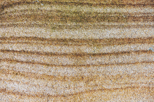 Panoramic close-up of a slab with abstract grainy texture of small stones in beige, brown, white and black