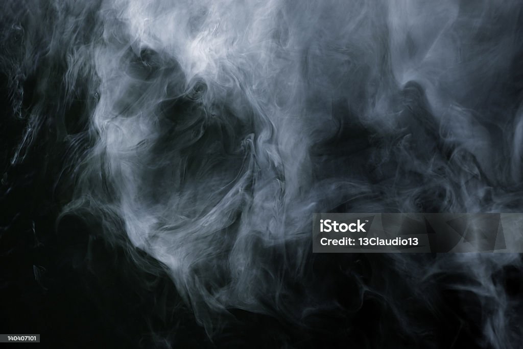 Smoke forming patterns on a black background Appearance of cigarette smoke forming the shape of a skull. Abstract Stock Photo