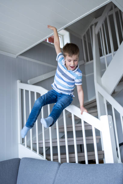 istock Boy sliding on the staircase in the house 1404071553