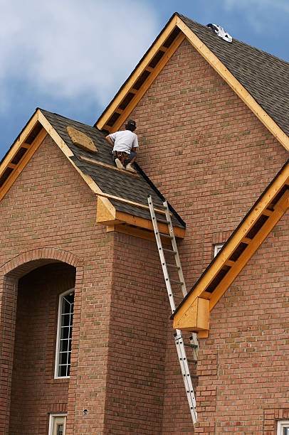 istock Construction worker laying new roofing tile on a brick house 140407185
