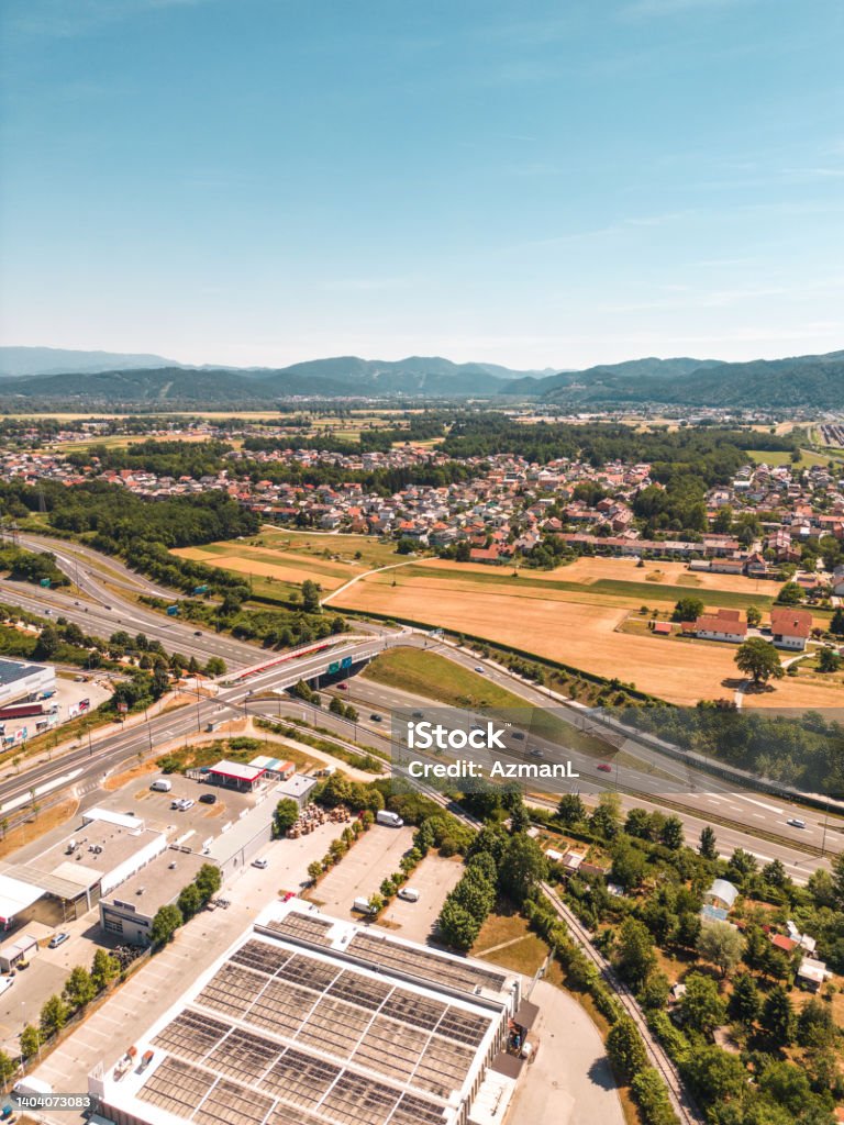 Coexistance of Industrial Buildings and Green Nature in Slovenia Dron shot of industrial building coexisting with green nature and city in Slovenia. Agricultural Field Stock Photo