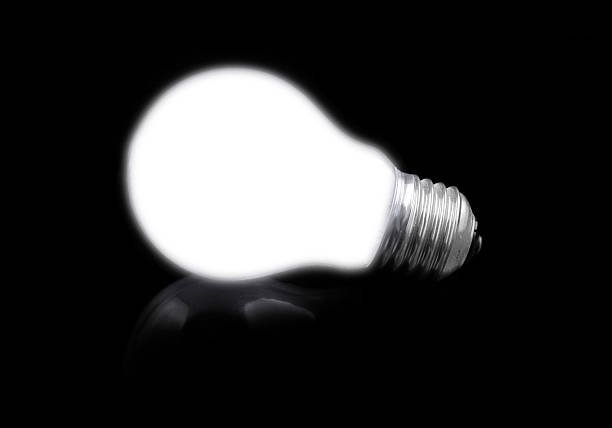 close-up of lit light bulb on black, see also: