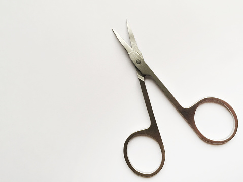 Manicure scissors on the white background with copy space