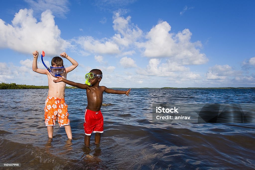 Beach Series - Diversity Two small boys playing with snorkel gear on a beach - one African American one Caucasian. John Pennecamp Park, Florida Keys. Child Stock Photo