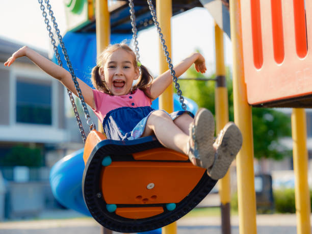 istock Little girl is swinging at play ground when sun is setting 1404080637