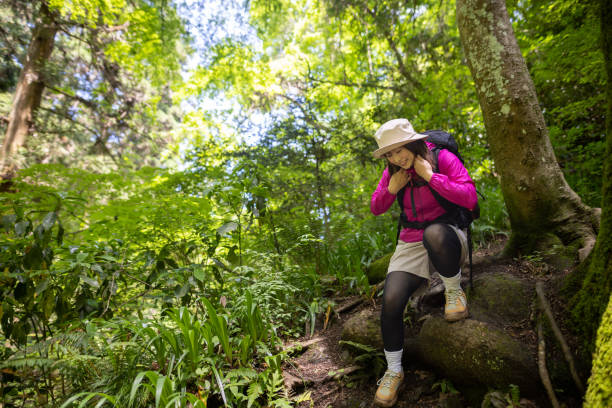 istock Woman walking down narrow footstep in forest / mountain 1404080970