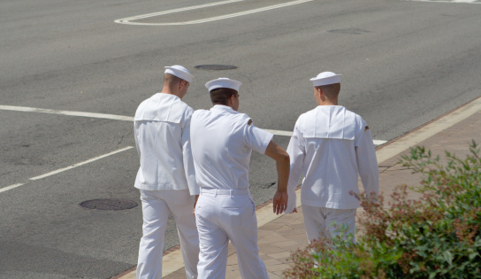 Three sailors walking down a street