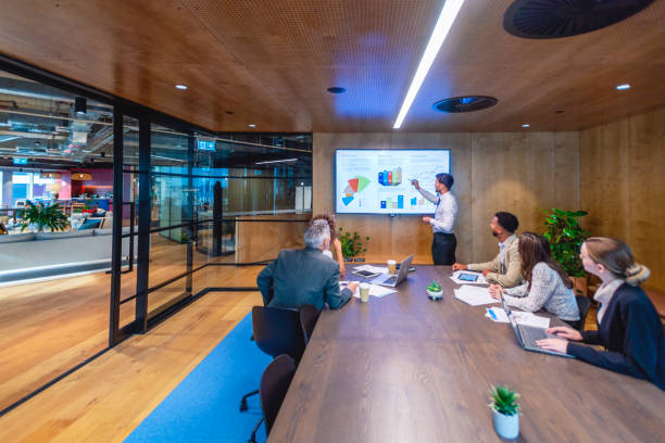 istock Man giving a big data presentation on a tv in a board room. 1404088329