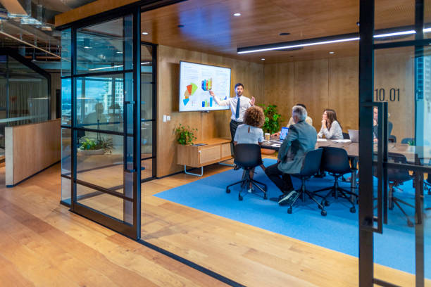 istock Man giving a big data presentation on a tv in a board room. 1404088331