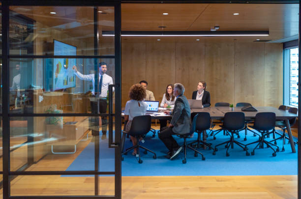 istock Man giving a big data presentation on a tv in a board room. 1404088335
