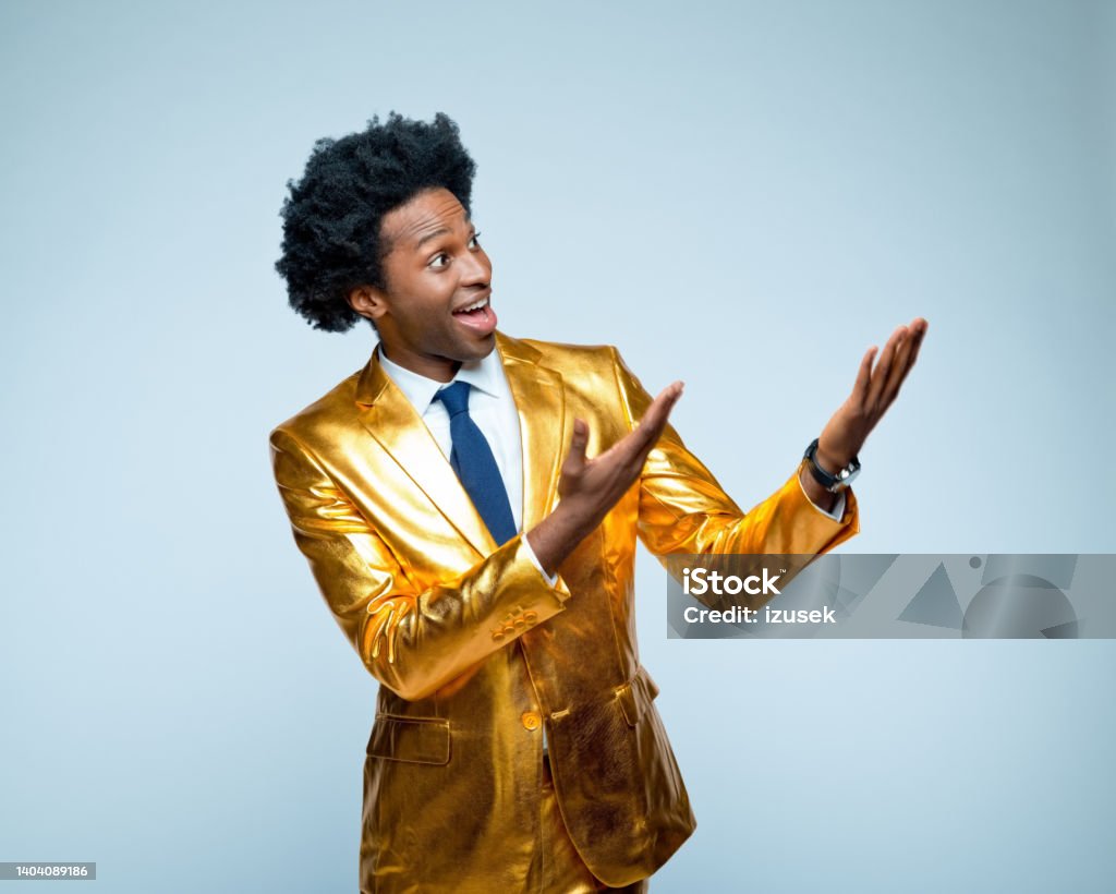 Man gesturing against blue background Businessman in golden suit gesturing against blue background Gold Colored Stock Photo