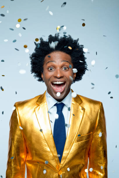 istock Happy man amidst confetti against blue background 1404090306