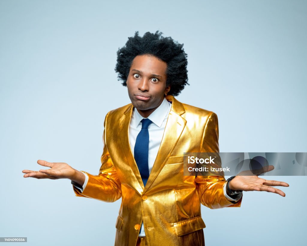 Confused man gesturing with facial expression Portrait of confused businessman gesturing with facial expression against blue background Gold Colored Stock Photo