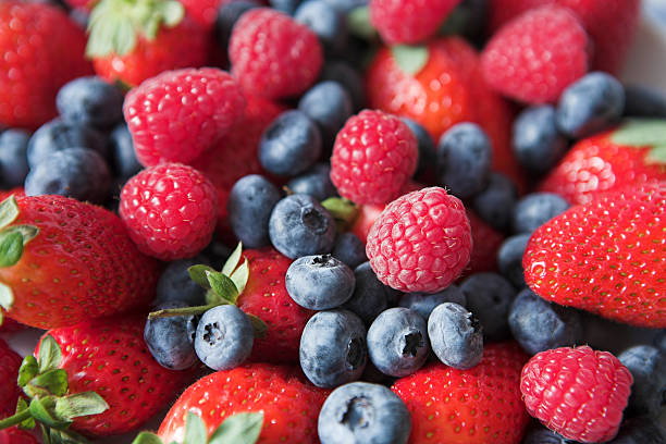 A mix of strawberries, blueberries, and raspberries stock photo