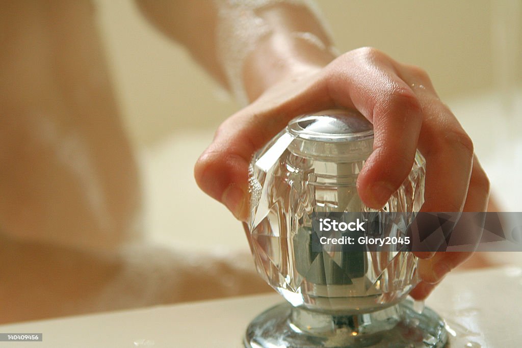 More Water Little childs hand on cold water knob of bathtub Anatomy Stock Photo