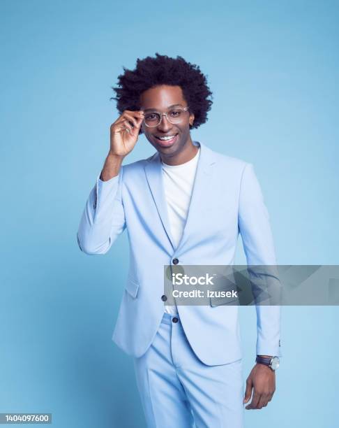 Smiling Man Adjusting Eyeglasses Stock Photo - Download Image Now - Blue Background, Formal Portrait, Men