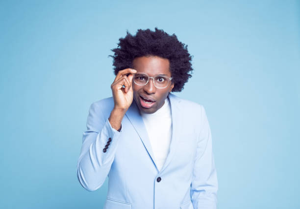 istock Man with facial expression adjusting eyeglasses 1404097704