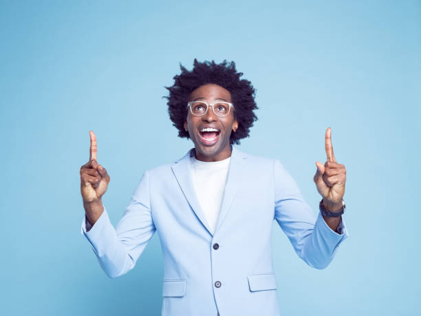 istock Man pointing with index fingers against blue background 1404097763